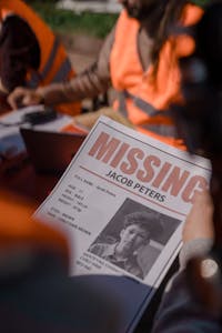 Group of volunteers organizing search efforts for a missing child. Focus on community teamwork.